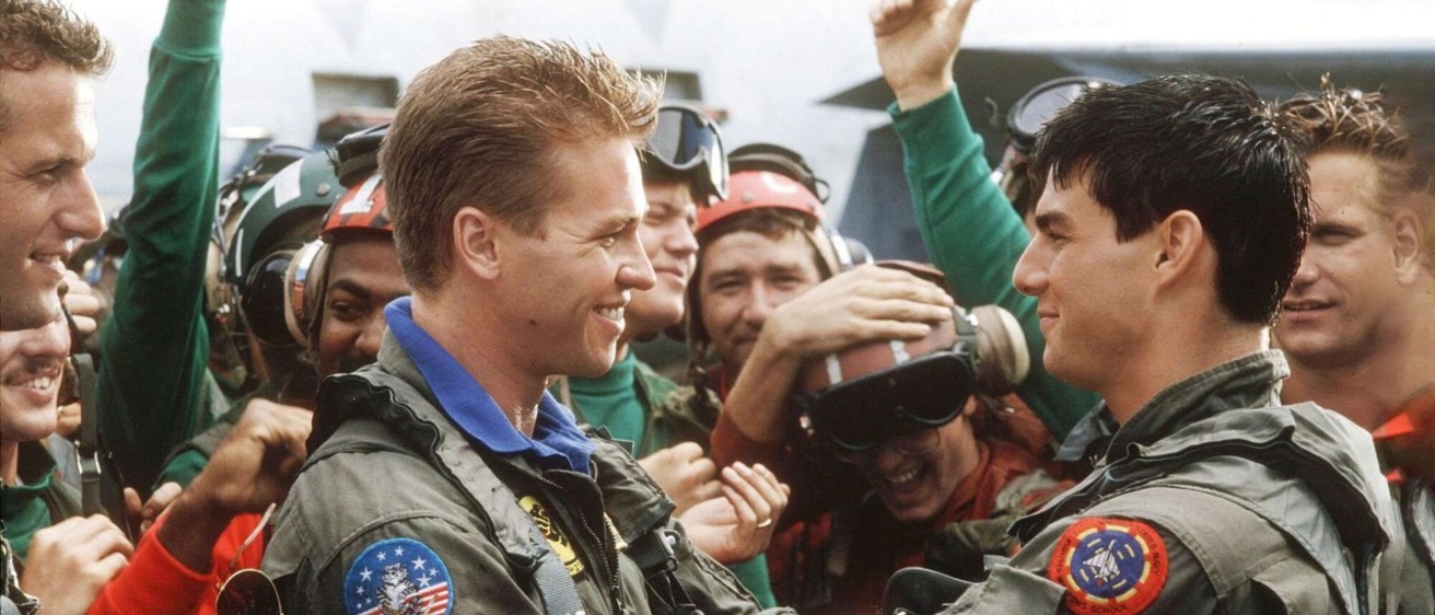 Maverick (Tom Cruise) and Iceman (Val Kilmer) embrace after a dogfight.