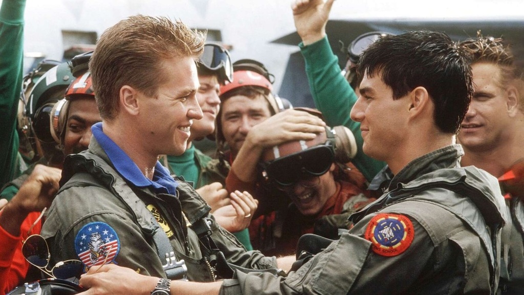 Maverick (Tom Cruise) and Iceman (Val Kilmer) embrace after a dogfight.